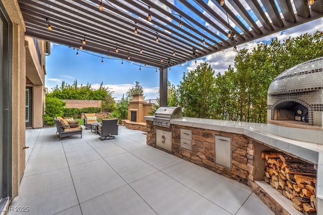 view of patio featuring an outdoor stone fireplace and area for grilling