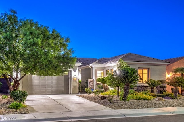 view of property hidden behind natural elements featuring driveway, an attached garage, a tile roof, and stucco siding