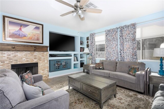 living room with built in shelves, ceiling fan, and light hardwood / wood-style floors