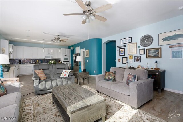 living room with ceiling fan and light hardwood / wood-style floors