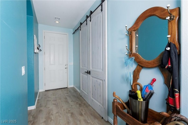 hallway featuring light hardwood / wood-style flooring and a barn door