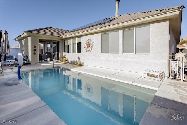 back of property with a patio and solar panels