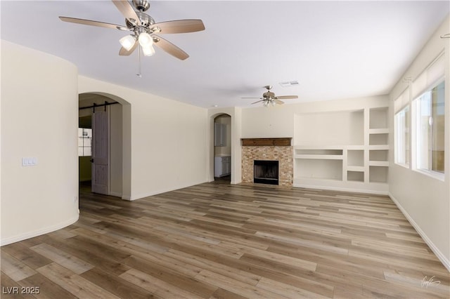 206 Pebble Creek Hts, Mesquite, NV 89027 - unfurnished living room featuring a ceiling fan, arched walkways, wood finished floors, and baseboards