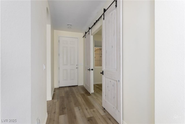 206 Pebble Creek Hts, Mesquite, NV 89027 - hall with a barn door, light wood finished floors, and baseboards