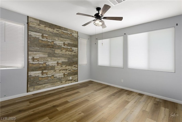 206 Pebble Creek Hts, Mesquite, NV 89027 - spare room featuring baseboards, wood finished floors, a ceiling fan, and an accent wall