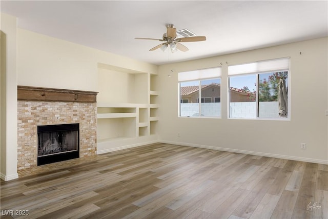 206 Pebble Creek Hts, Mesquite, NV 89027 - unfurnished living room with ceiling fan, light wood-style flooring, a fireplace with flush hearth, and baseboards