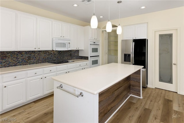 206 Pebble Creek Hts, Mesquite, NV 89027 - kitchen featuring white appliances, a kitchen island, light wood-style flooring, backsplash, and recessed lighting