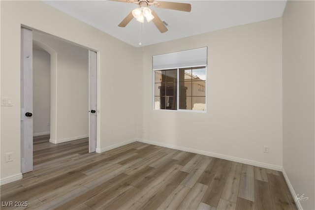 206 Pebble Creek Hts, Mesquite, NV 89027 - spare room featuring wood finished floors, ceiling fan, baseboards, and arched walkways