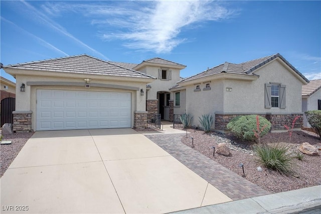 206 Pebble Creek Hts, Mesquite, NV 89027 - view of front of home featuring stone siding, stucco siding, driveway, and an attached garage