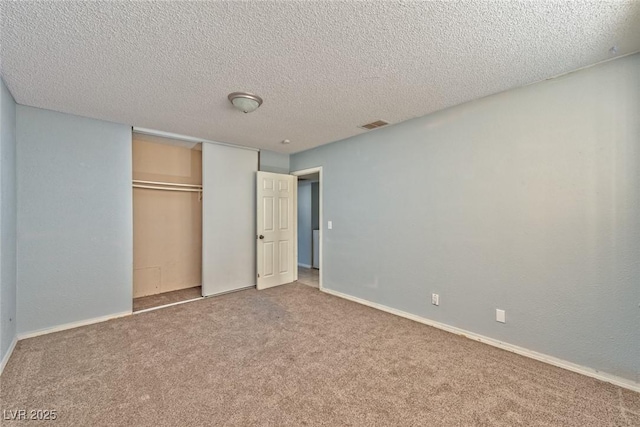 unfurnished bedroom with carpet flooring, a textured ceiling, and a closet