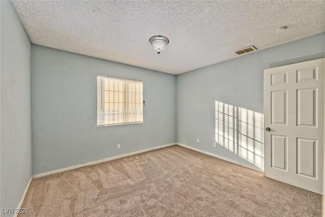 unfurnished room featuring carpet flooring and a textured ceiling