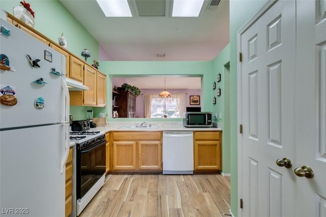 kitchen featuring sink, white appliances, light wood-type flooring, and pendant lighting