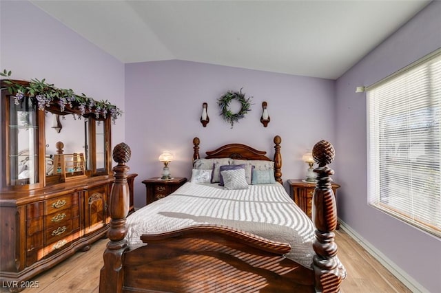 bedroom with lofted ceiling and light wood-type flooring