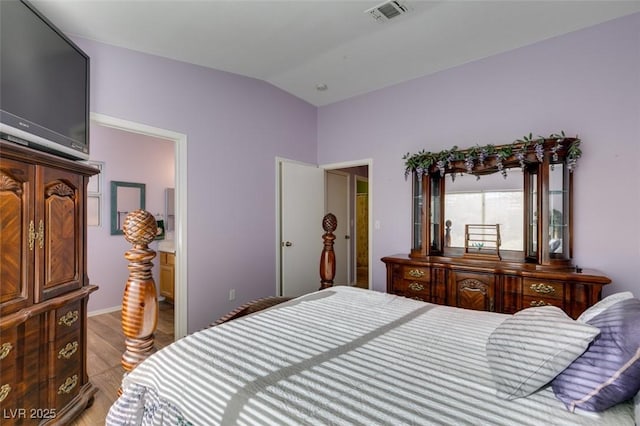 bedroom with lofted ceiling and light wood-type flooring