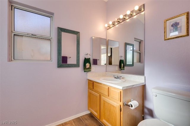 bathroom with toilet, vanity, and hardwood / wood-style flooring