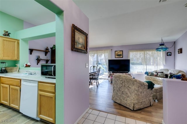 kitchen featuring light hardwood / wood-style floors, white dishwasher, pendant lighting, light brown cabinets, and sink