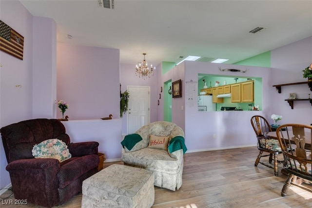 living room with a notable chandelier and light hardwood / wood-style floors