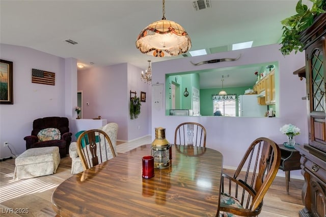 dining room with a notable chandelier and light hardwood / wood-style floors