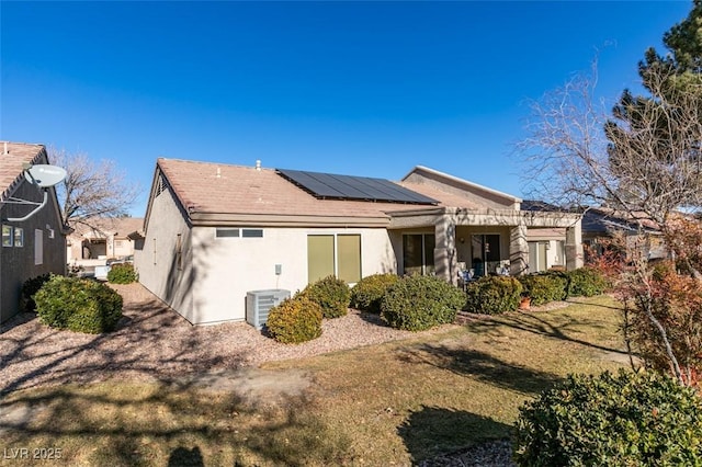 rear view of property featuring solar panels, central air condition unit, a yard, and a pergola