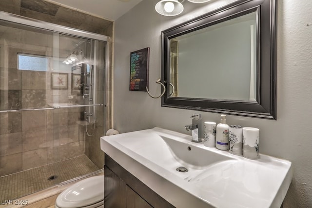 bathroom featuring an enclosed shower, vanity, and toilet