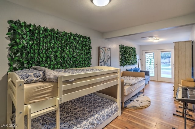 bedroom featuring wood-type flooring, access to outside, and french doors