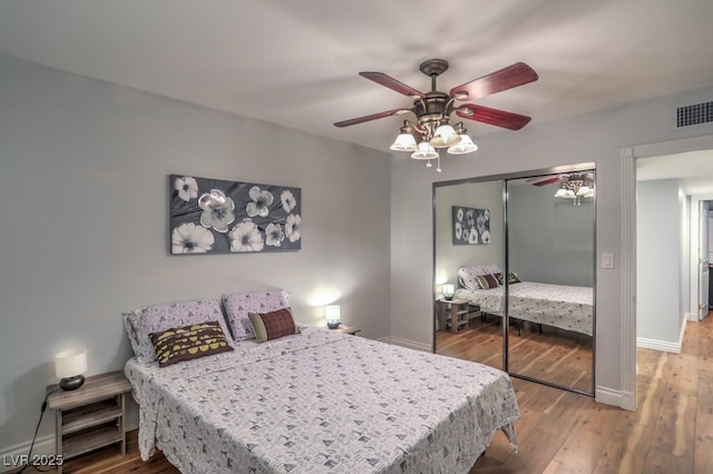 bedroom featuring a closet, wood-type flooring, and ceiling fan