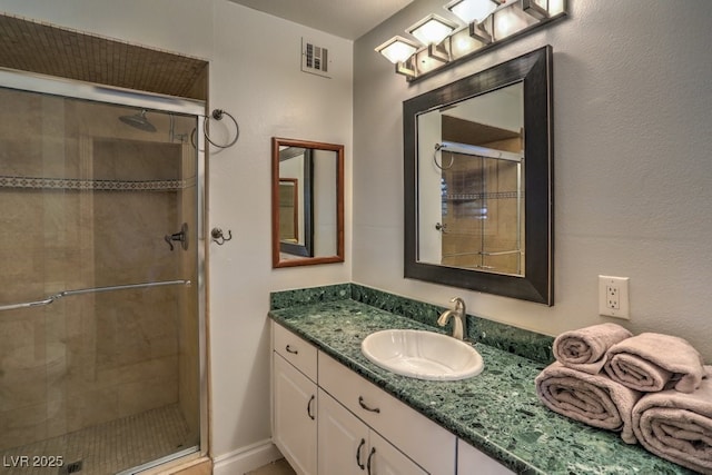 bathroom with vanity and a shower with door