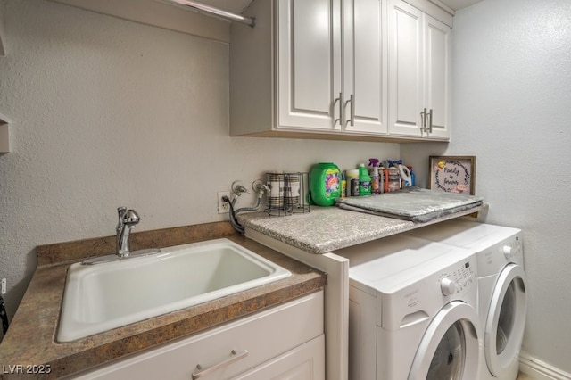 laundry area featuring washer and dryer, sink, and cabinets