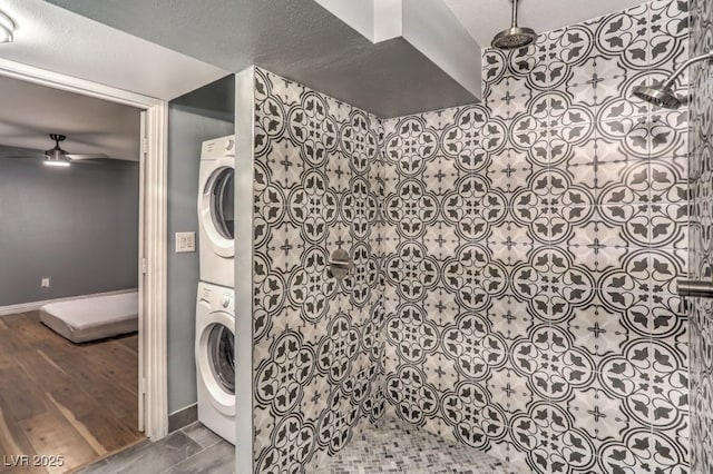 washroom featuring ceiling fan and stacked washer / dryer