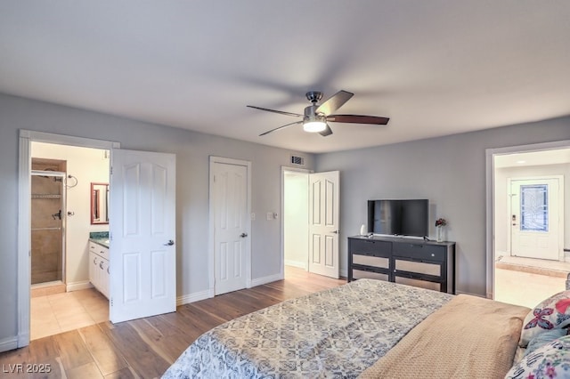 bedroom featuring ceiling fan, ensuite bathroom, a closet, and light wood-type flooring