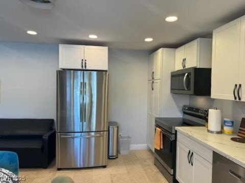 kitchen featuring light stone countertops, white cabinets, and appliances with stainless steel finishes