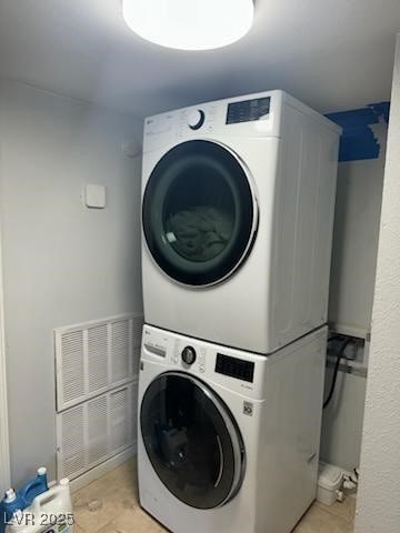 clothes washing area featuring stacked washing maching and dryer