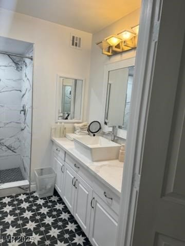 bathroom with vanity and a tile shower