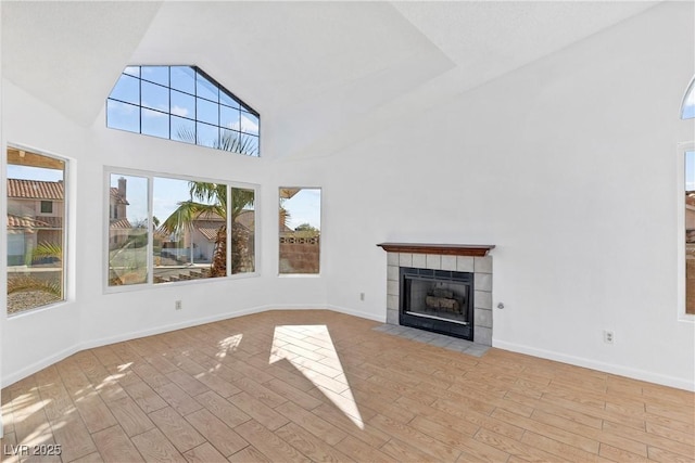 unfurnished living room featuring a tiled fireplace and light wood-type flooring