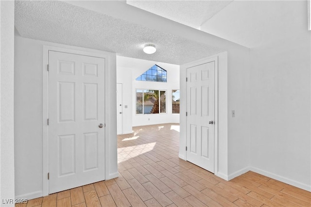 interior space with a textured ceiling and light hardwood / wood-style flooring