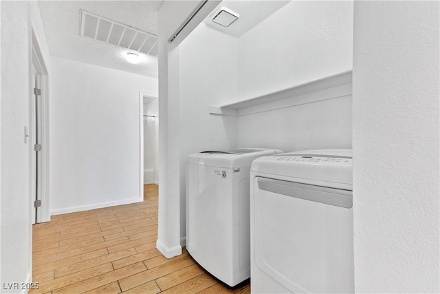 laundry room with separate washer and dryer and a textured ceiling