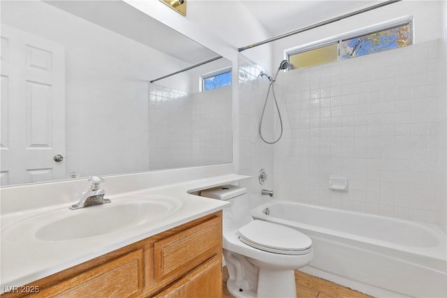 full bathroom with toilet, vanity, wood-type flooring, and tiled shower / bath combo