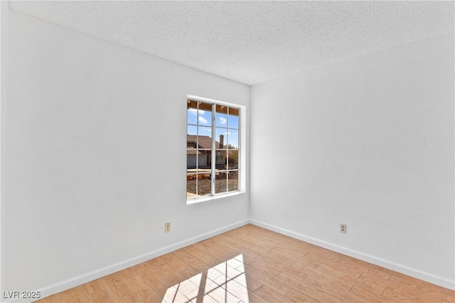 unfurnished room with a textured ceiling and hardwood / wood-style flooring