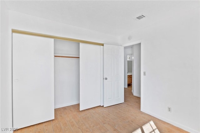 unfurnished bedroom with a closet and light hardwood / wood-style floors