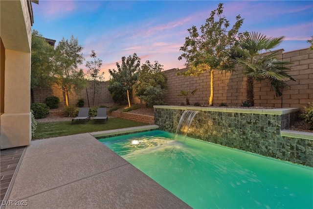 pool at dusk featuring pool water feature