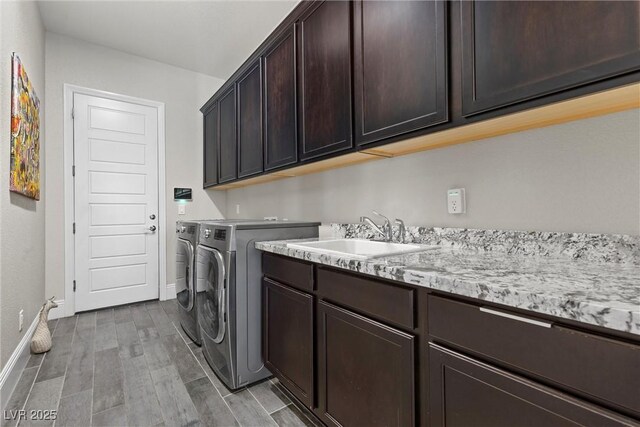 washroom featuring cabinets, washing machine and clothes dryer, and sink