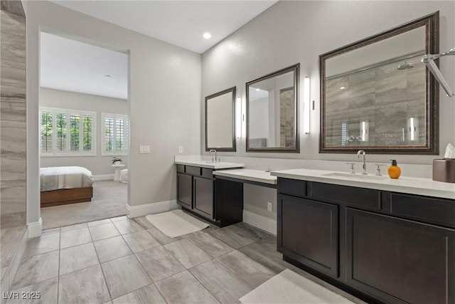 bathroom with a tile shower, vanity, and tile patterned floors