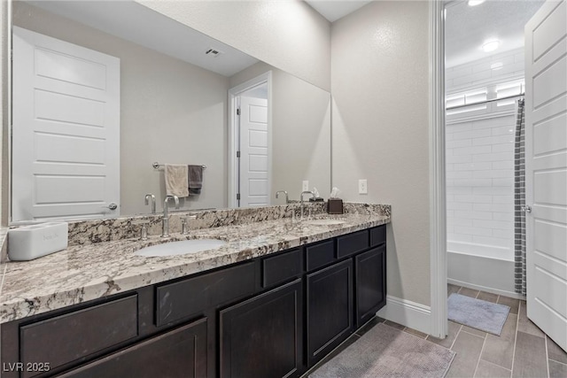 bathroom featuring vanity and tiled shower / bath