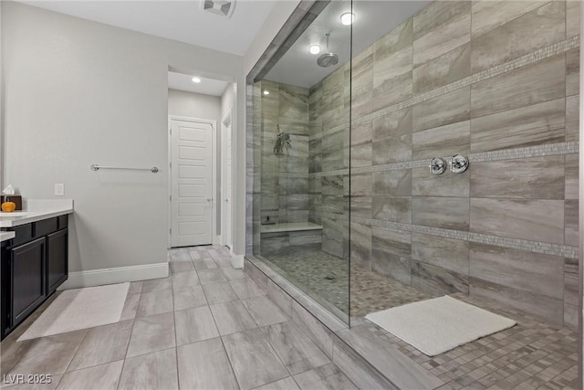 bathroom featuring a tile shower and vanity