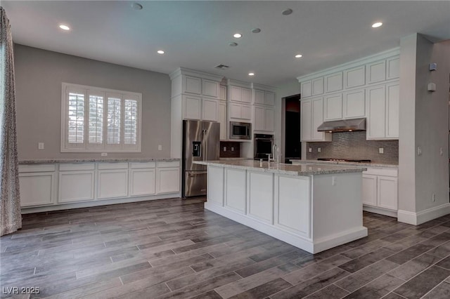 kitchen featuring decorative backsplash, under cabinet range hood, stainless steel appliances, and white cabinets