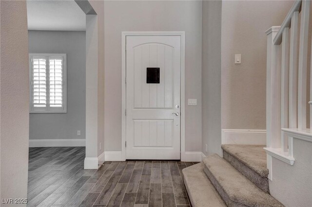 foyer entrance with baseboards, stairway, and dark wood finished floors