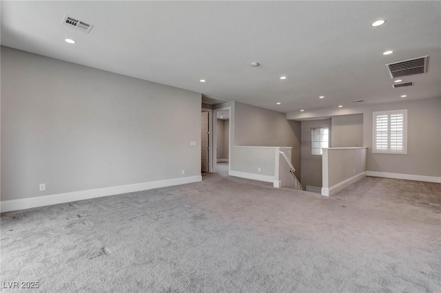spare room featuring recessed lighting, carpet, visible vents, and baseboards