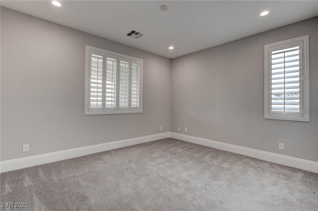 carpeted empty room featuring recessed lighting, visible vents, and baseboards