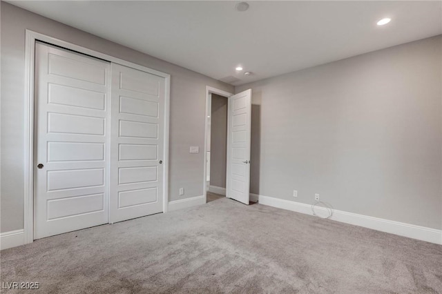unfurnished bedroom with baseboards, recessed lighting, a closet, and carpet