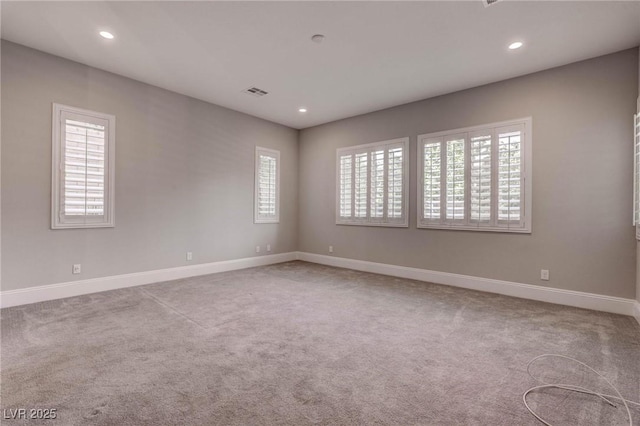 empty room featuring a healthy amount of sunlight, visible vents, and recessed lighting